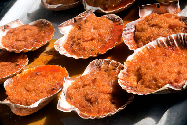 Display of stuffed  cooked scallops served on their shells. Market stall, O Grove, Pontevedra province, Galicia, Spain.