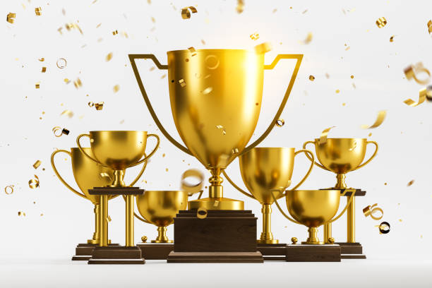istock Golden champion trophies and confetti on white 1162930291