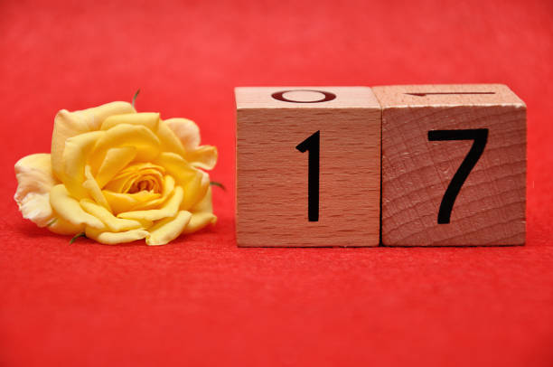istock Number seventeen with a yellow rose on a red background 1162935697