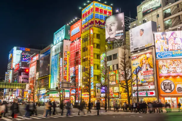 The neon lights of Akihabara illuminating the crowded night streets of the popular shopping and entertainment district in the heart of Tokyo, Japan’s vibrant capital city.