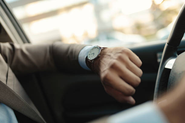 istock Businessman is Looking at Watch in His Car 1162937006