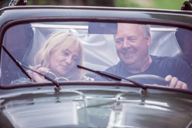 istock Mature Couple Having Fun while Driving Vintage Car 1162940825