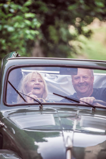 istock Mature Couple Having Fun while Driving Vintage Car 1162940940
