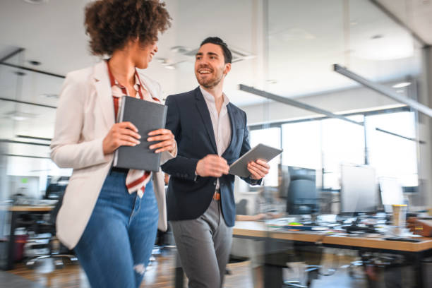 istock Young Business Colleagues Walking and Talking in Office 1162941368