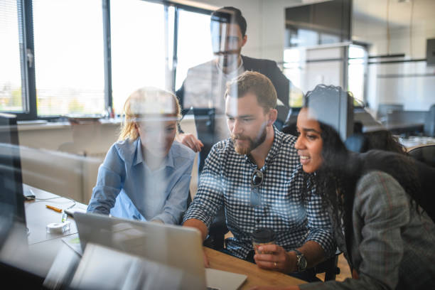 istock Motivated Businesspeople Working Together with Laptop 1162941414