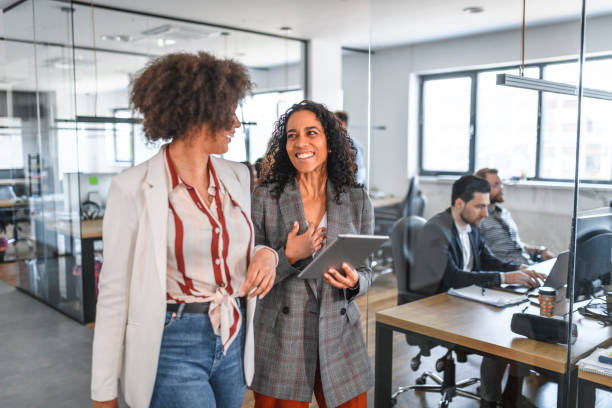 istock Cheerful Mixed Race Businesswomen Walking Through Office 1162941481