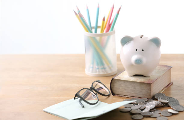 Piggy bank with glasses and black bank book, economical and educational concepts stock photo