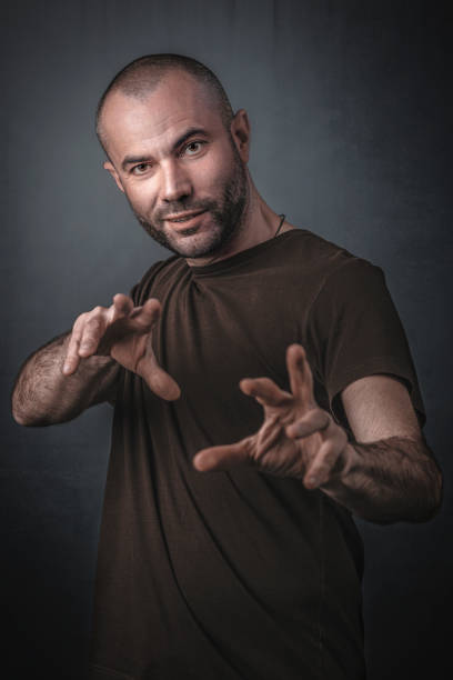 istock Portrait Of Man Gesturing While Standing Against Gray Background 1162942584
