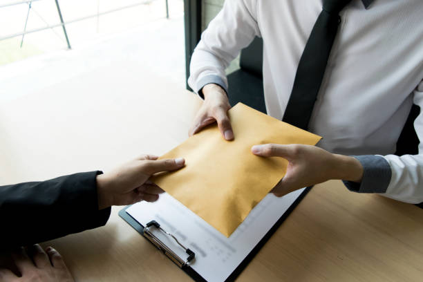 istock Cropped Hand Giving Envelope To Businessman At Table 1162946614