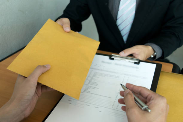 istock Cropped Hand Giving Envelope To Businessman At Table 1162948342