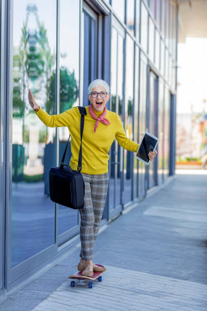 istock Senior Businesswoman Standing On Skateboard 1162949129
