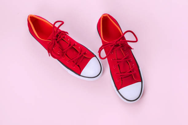 istock New red sneakers on pink background with copy space. 1162951365