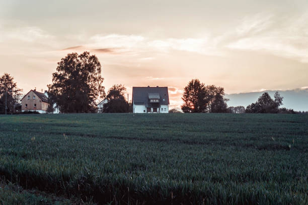Beautiful spring landscape and small village in Germany at sunset. Green field.
