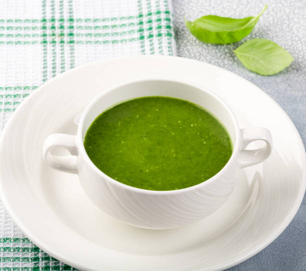 концепция здоровой, вегетарианской или диетической пищи: кремовый суп из шпината, с кедровыми орешками и базиликом. с ломтиками вегетариан� - soup zucchini spinach cream стоковые фото и изображения