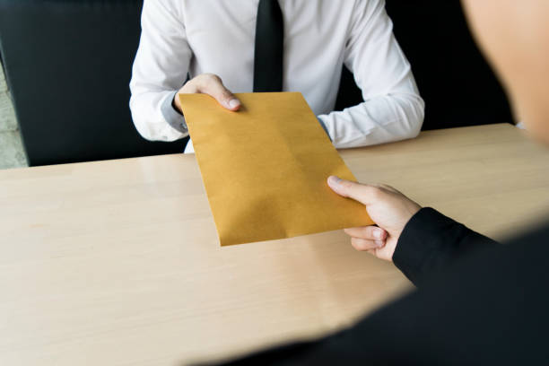 istock Cropped Hand Giving Envelope To Businessman At Table 1162952244