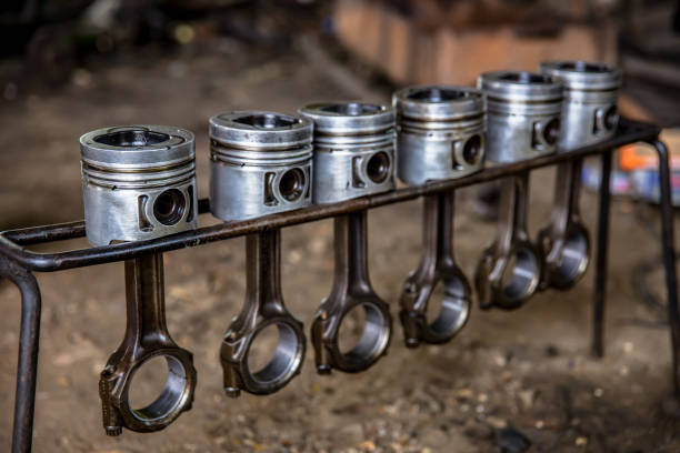 Selective focus. Engine Block on a repair stand with Piston and Connecting Rod of Automotive technology. Blurred car on background. Interior of a car repair shop