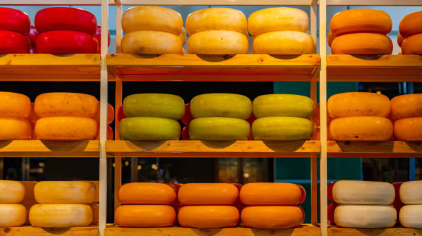 Dutch cheeses, edam, gouda, whole round wheels on wooden shelf, cheese store in Rotterdam, Netherlands Dutch cheeses, edam, gouda, whole round wheels on wooden shelf, cheese store in Rotterdam, Netherlands. Texture, background cheese market stock pictures, royalty-free photos & images