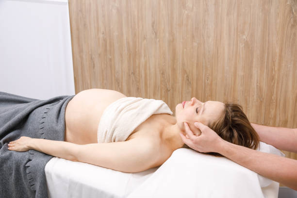 donna incinta che riceve un trattamento osteopatico della testa - osteopath chiropractic adjustment skull massaging foto e immagini stock