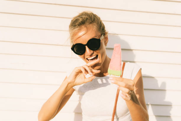 The girl licks her fingers soiled thawed popsicle