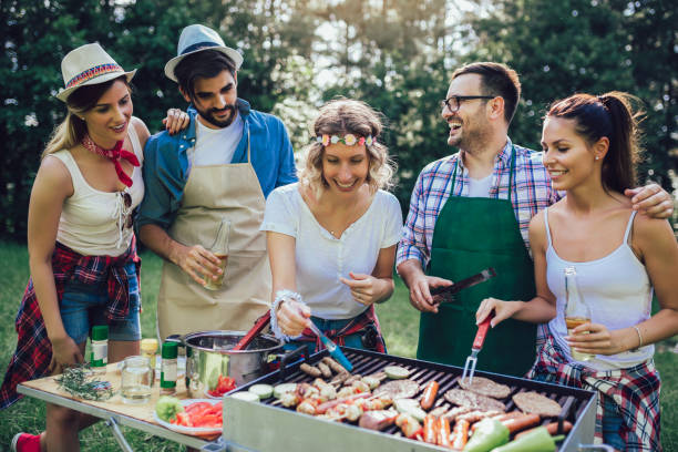 istock Young friends having fun grilling meat enjoying barbecue party. 1162959870