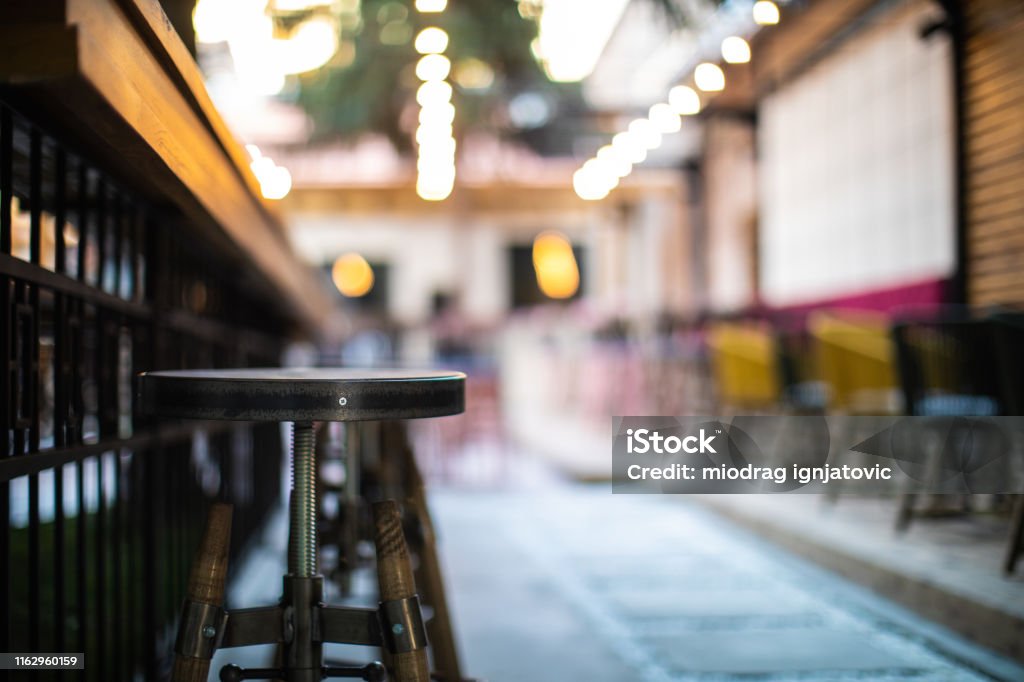 Everything is ready for a party Close up of wooden bar stools in an outdoor cafe on day Outdoors Stock Photo