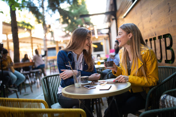 istock Attractive women having coffee in sidewalk cafe 1162960420