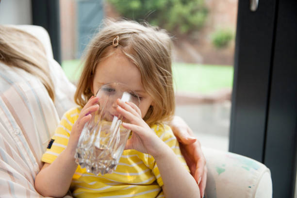 young mother enjoying her time with daughter, having a glass of water