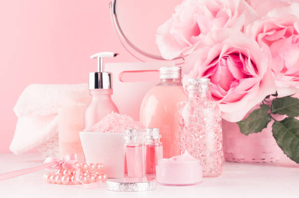 istock Romantic bathroom interior in pastel pink, silver color - flowers, round mirror, bath accessories, cosmetic products - cream, salt, rose oil, soap on white wood table. 1162963143