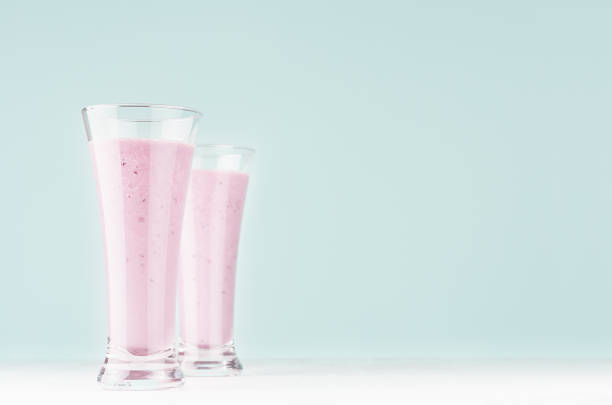 istock Light joyful spring milk drinks with blueberry on modern pastel mint green color background and white wood table, copy space. 1162963326