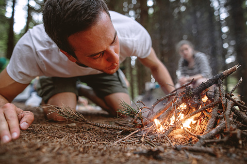 Man preparing a campfire for his camp