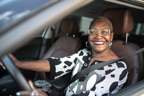 portrait of a senior woman driving a car - senior adult 70s female women imagens e fotografias de stock