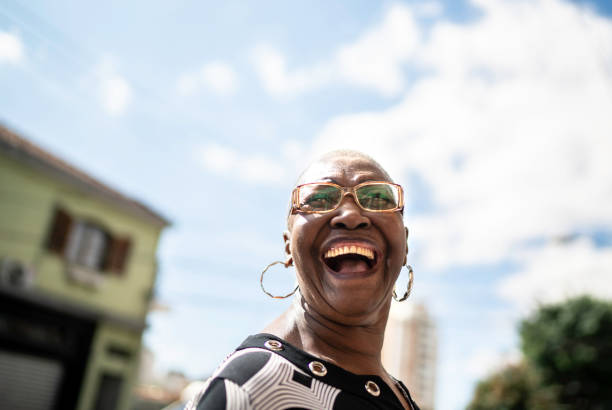 portret van lachende senior vrouw in city street - kaal geschoren hoofd stockfoto's en -beelden