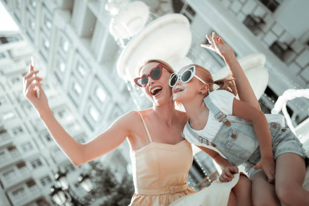 istock Mother and daughter playing the ape taking selfie. 1162969095