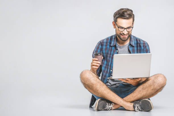 istock Online working concept. Casual business man relaxed working and browsing internet on laptop computer with coffee. Freelance sitting and typing on laptop keyboard at home office. 1162970048