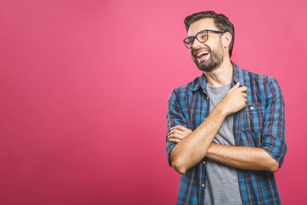 portret przystojnego przypadkowego mężczyzny, który śmieje się, stoi i śmieje się na różowym tle - laughing zdjęcia i obrazy z banku zdjęć