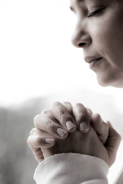 istock Woman praying at home 1162970689
