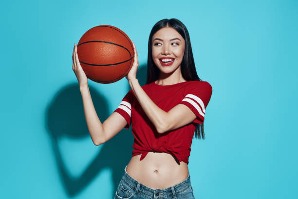 istock Favorite game. Attractive young Asian woman smiling while standing against blue background 1162974264