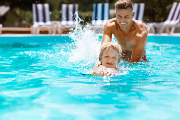 istock Happy father teaching his cute lovely son swimming 1162974479