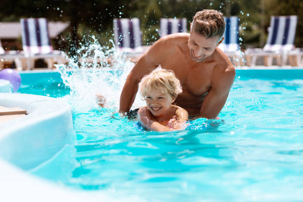 istock Athletic handsome man having fun with son in swimming pool 1162974481