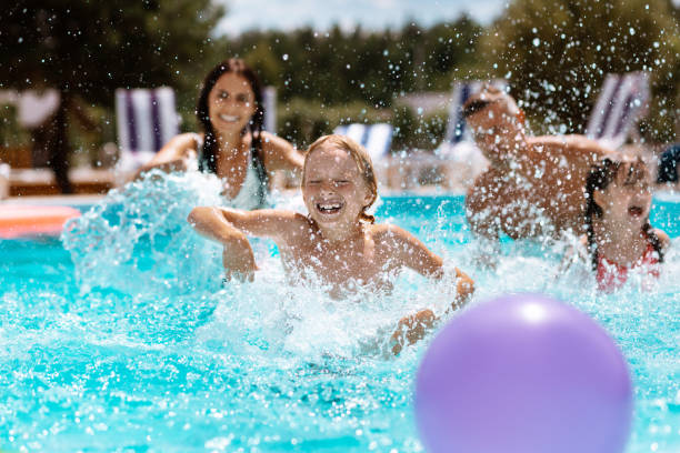 istock Parents and children laughing while playing ball in swimming pool 1162974518