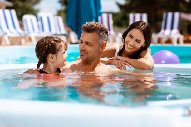 istock Daughter feeling happy swimming in pool with parents 1162974521