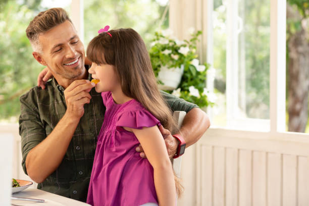 istock Daddy smiling while giving his cute daughter piece of candy 1162974783