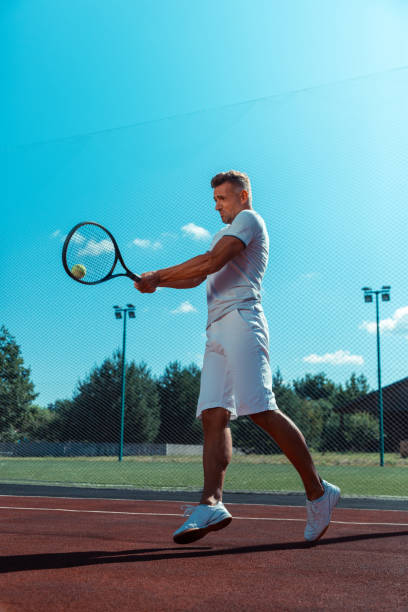 mężczyzna skacze podczas treningu na korcie przed grą w tenisa - businessman exercising training muscular build zdjęcia i obrazy z banku zdjęć