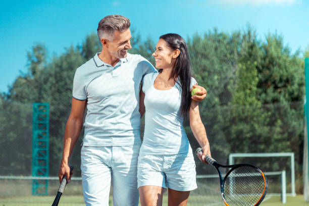 istock Handsome husband hugging wife after successfully playing tennis 1162974883
