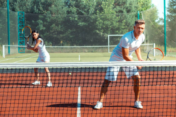istock Couple feeling joyful while training on court playing tennis 1162974887