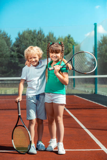 istock Brother and sister hugging while feeling happy after playing tennis 1162974911