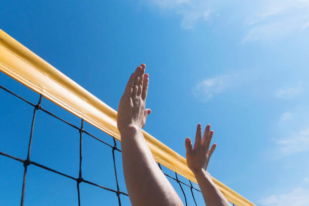 волейбол шип руку блок над сетью. крупным планом достичь мяча - volleyball volleying block human hand стоковые фото и изображения