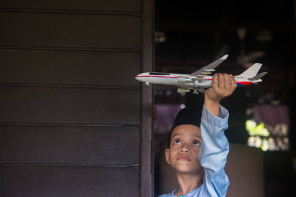 Malaysian child playing model airplane during Merdeka celebration