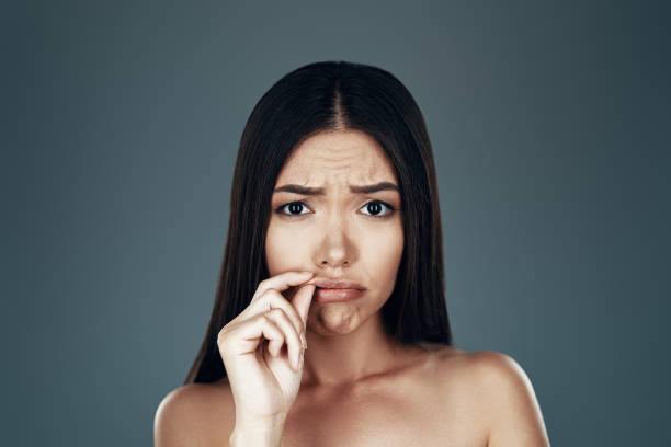 istock Feeling bad. Displeased young Asian woman looking at camera and making a face while standing against grey background 1162983523