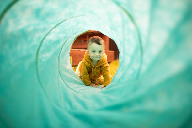 istock Baby girl crawling through play tunnel 1162983957